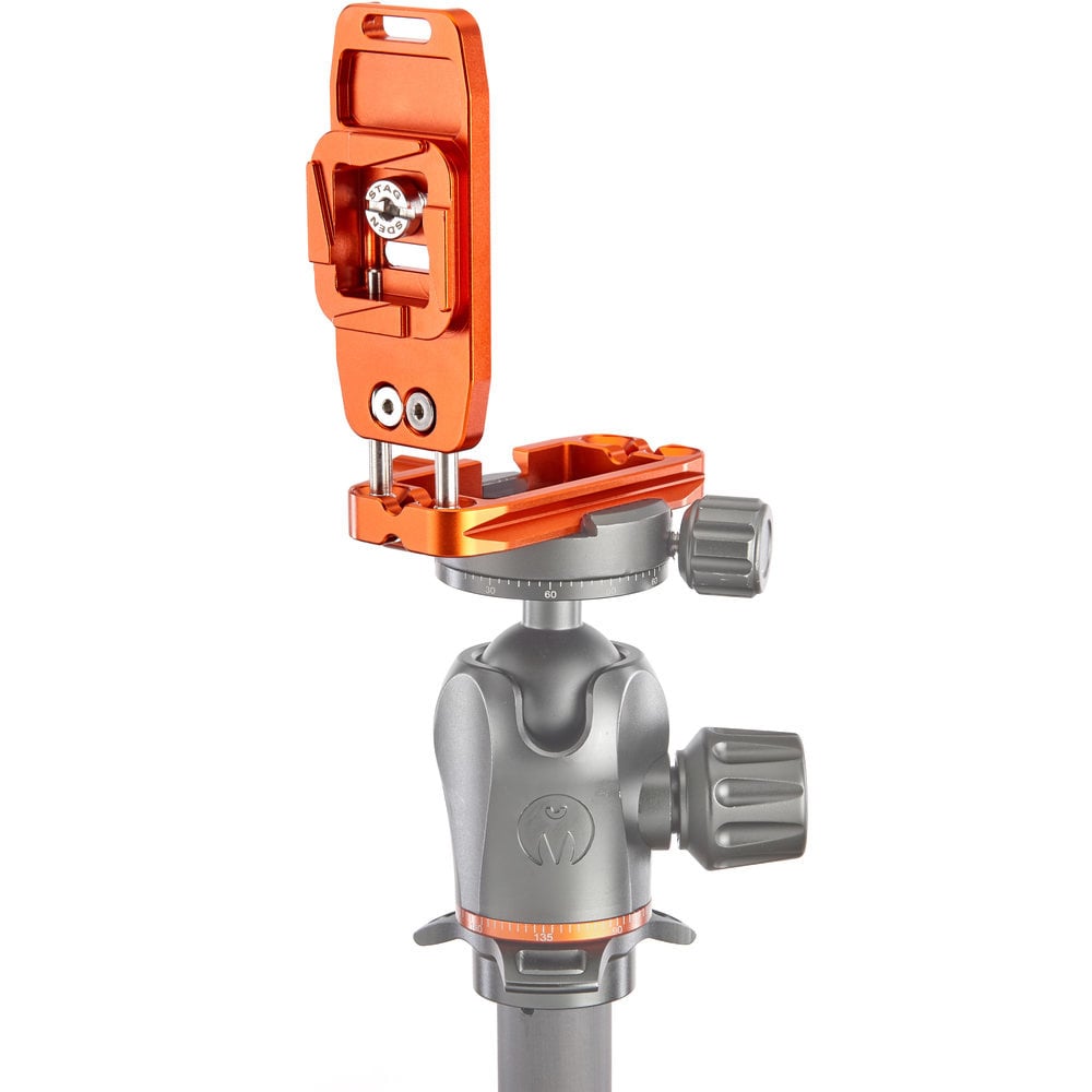Camera tripod head with orange quick release plate on a white background