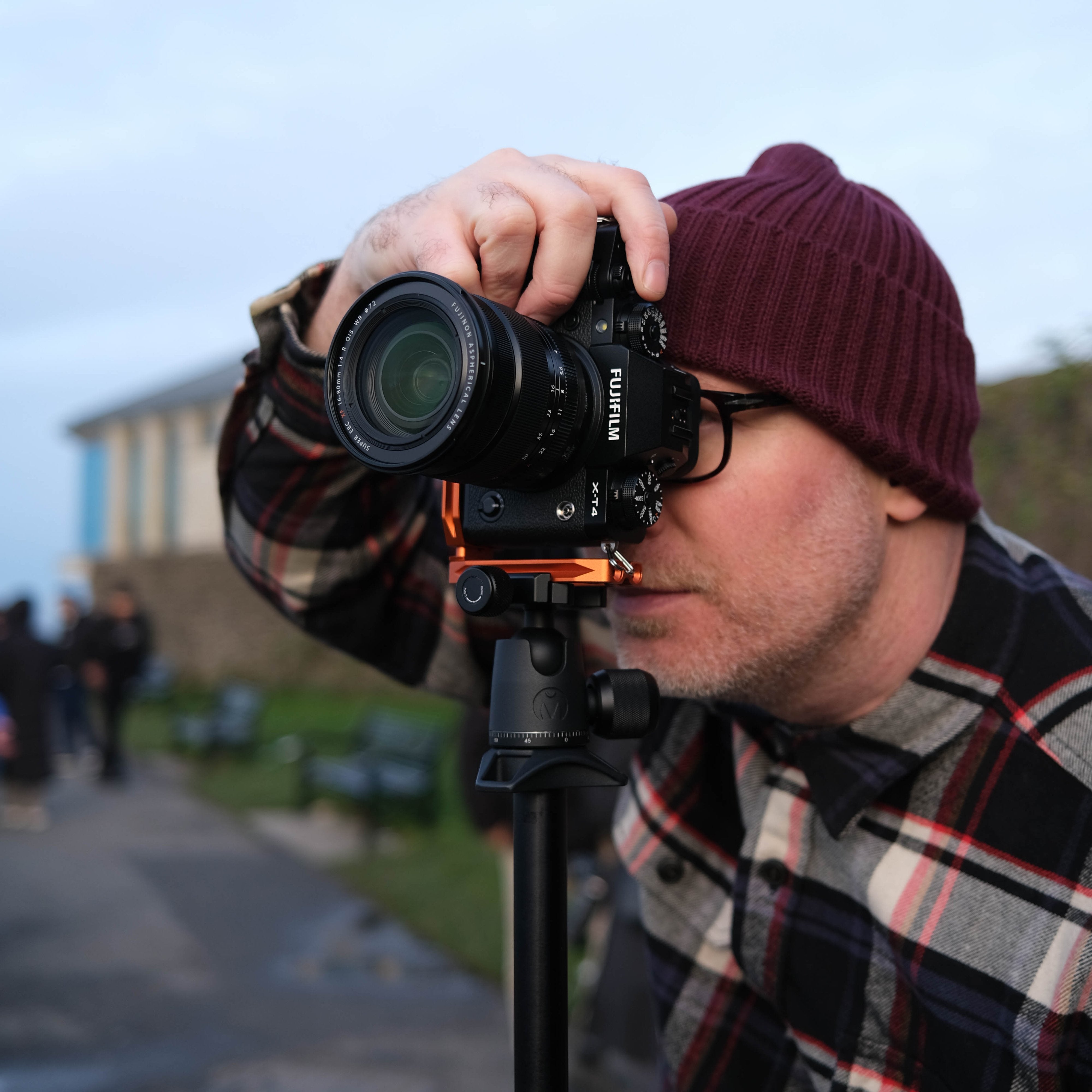 Person taking a photo with a camera on a tripod outdoors