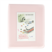Pink photo album with a window displaying an Instax camera and van design on a white background