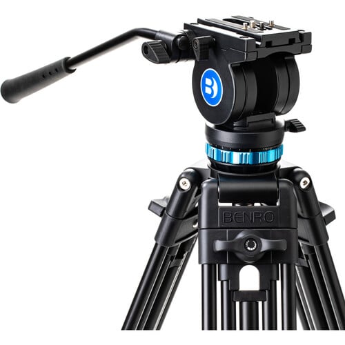 Benro KH25P video tripod in black with fluid video head attached, featuring three-section adjustable legs with flip locks, integrated mid-level spreader, retractable spiked rubber feet, ergonomic fluid pan‑tilt head with control arms, quick‑release camera plate, and built-in bubble level.