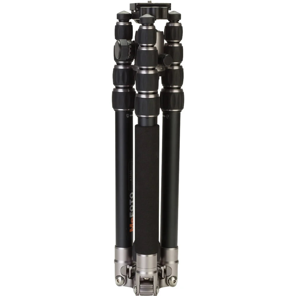 MeFoto RoadTrip aluminium tripod with reverse-folding legs, extending to 156.5 cm, supporting up to 8 kg, and converting into a full-size monopod via a removable foam-cushioned leg. Features two-position leg angle stops, spring-loaded centre column hook, Arca-type quick release plate, double action ball head with 360° pan, and included carry case.