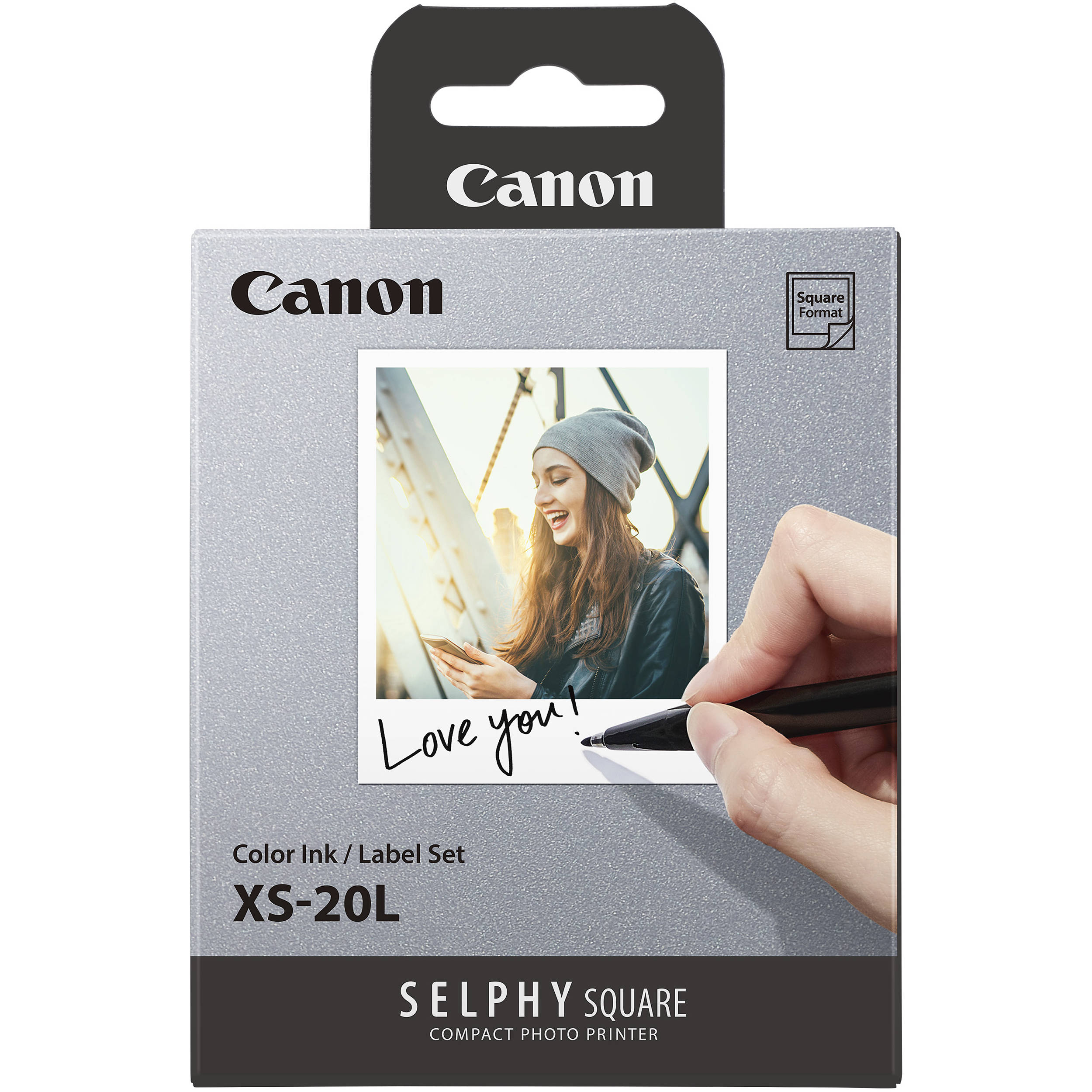 Canon Selphy Square photo printer ink cartridge packaging with a hand writing 'Love you!' on a photo.