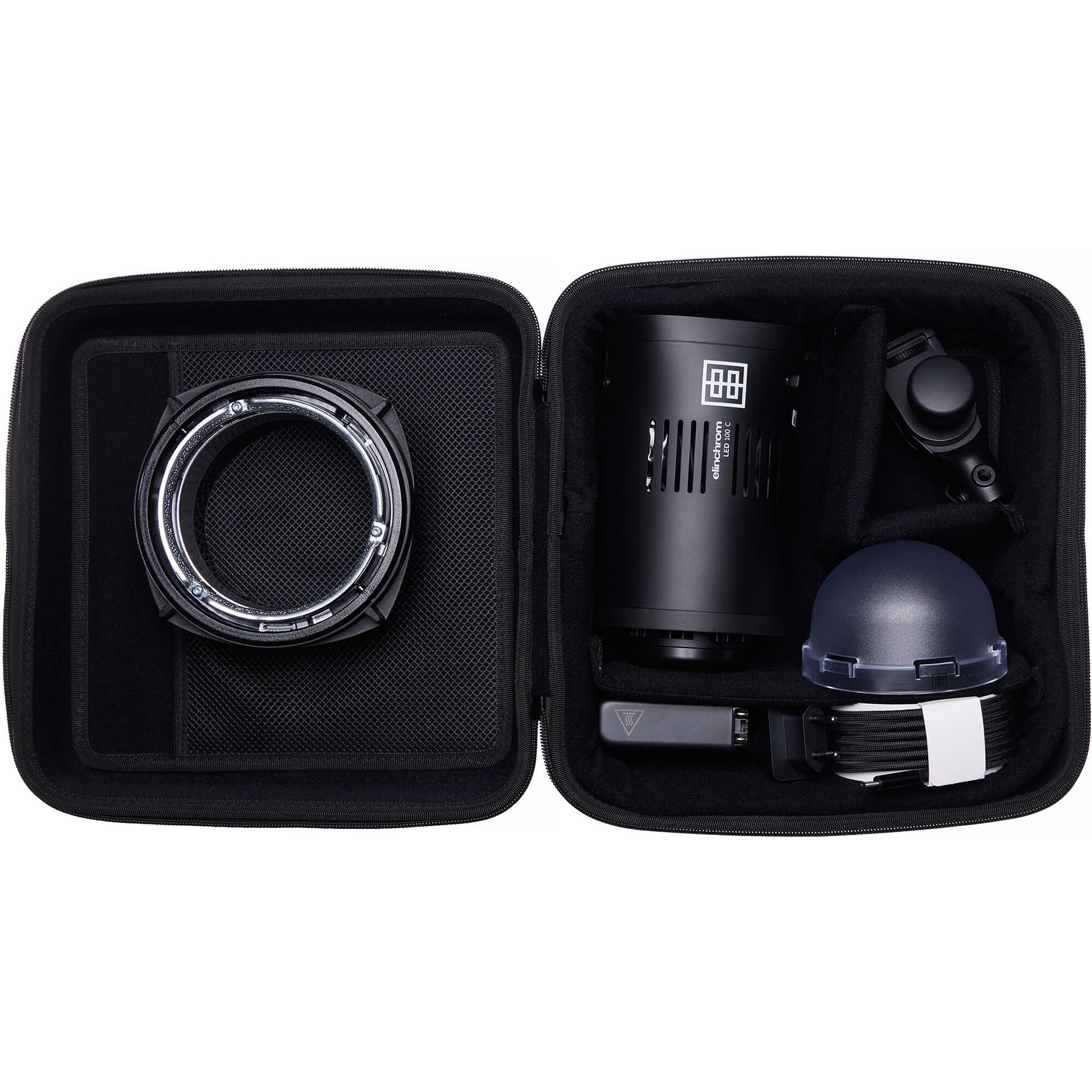 Black camera lens and accessories in a travel case on a white background