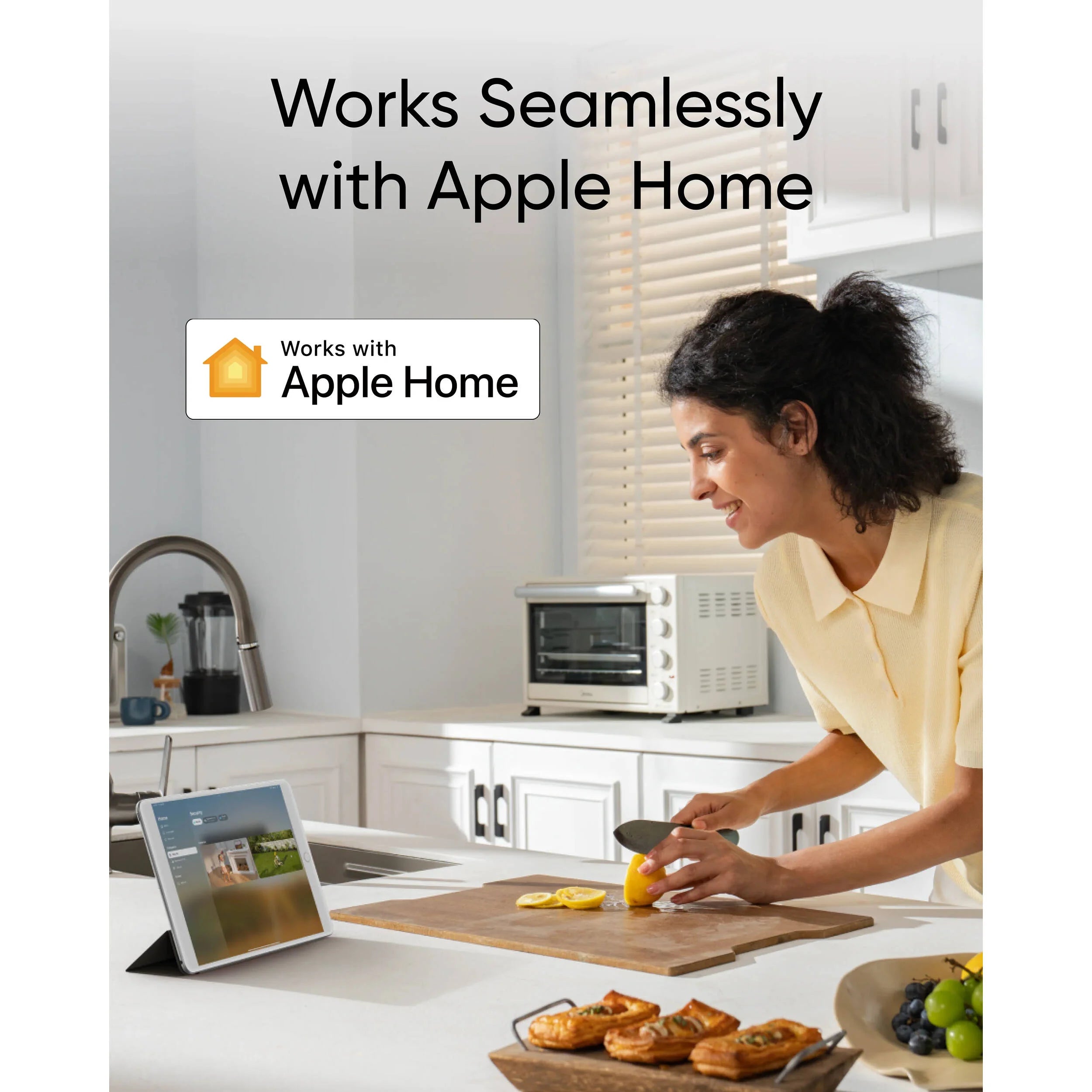 Woman in a kitchen using a tablet with 'Works with Apple Home' label