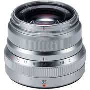 Silver camera lens with focus and aperture controls on a white background