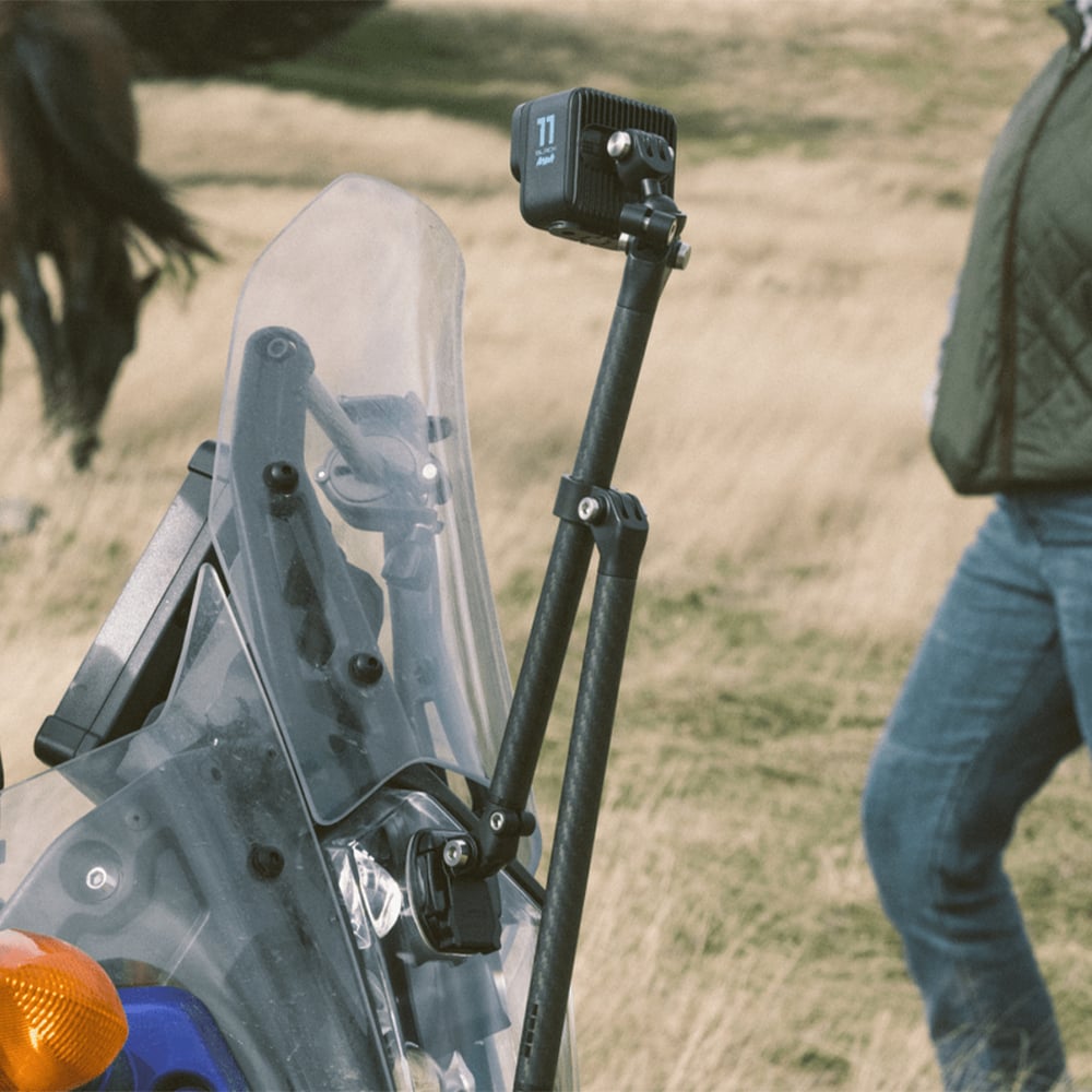 GoPro Boom + Adhesive Mounts kit with dual folding carbon fiber arms extending 25-53cm, ball-joint camera mount with 360° swivel, flat and curved adhesive mounts, and triangulation support slider for versatile and stable camera angles.