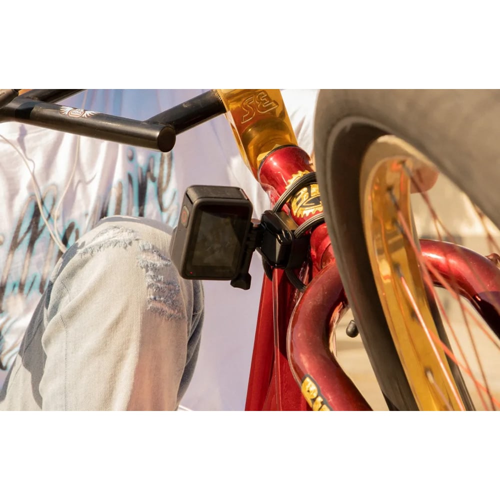 Close-up of a red bicycle with gold accents, focusing on the handlebar and front wheel.