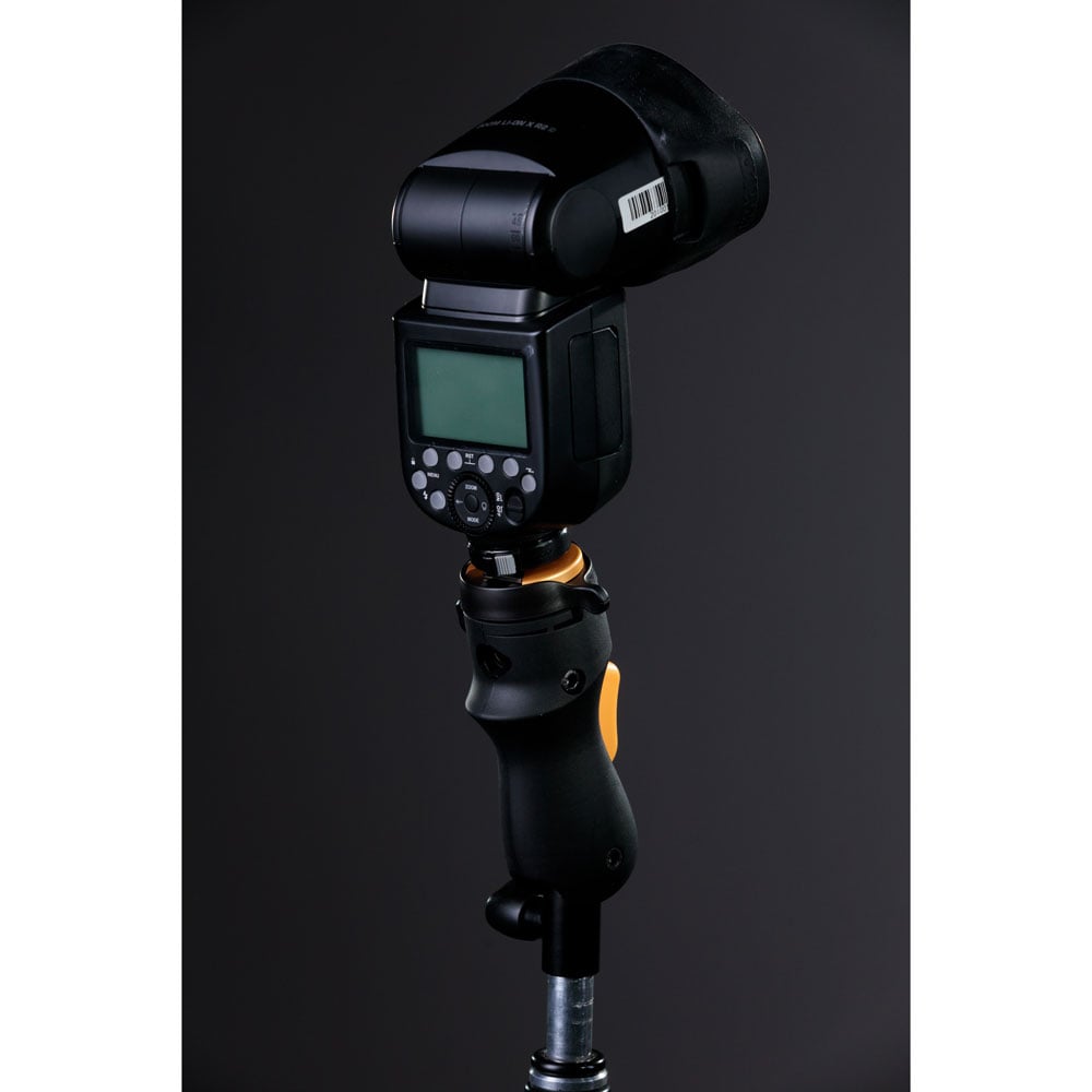 MagMod MagShoe 2 universal cold shoe bracket – ergonomic grip with orange release lever, locking mechanism for one-handed flash or modifier mounting.
