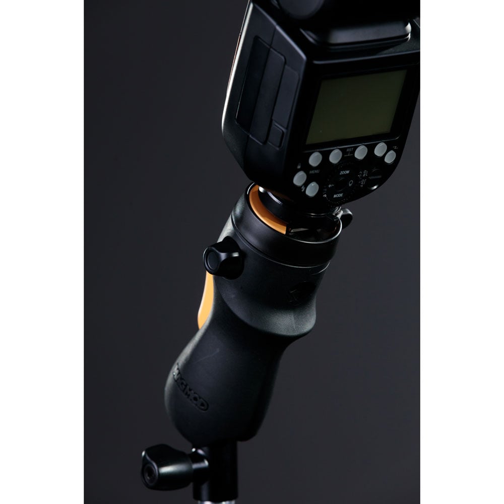MagMod MagShoe 2 universal cold shoe bracket – ergonomic grip with orange release lever, locking mechanism for one-handed flash or modifier mounting.