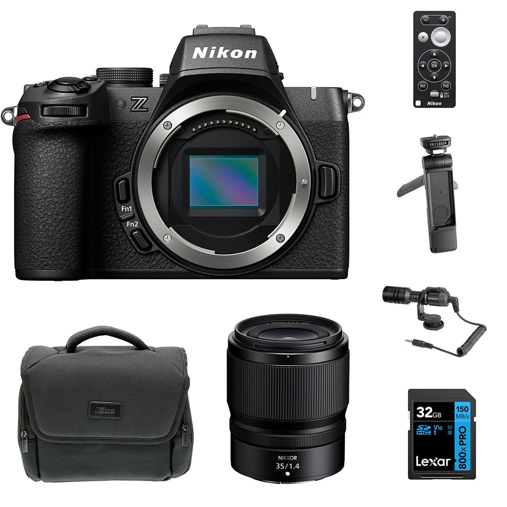 Nikon Z50 II Vlogging Kit in black featuring the Z50 II mirrorless camera body with attached NIKKOR Z 16–50 mm lens, alongside accessories including a compact vlogging LED light, shotgun microphone on cold shoe, handheld grip with wrist strap, and USB-C cable for charging.