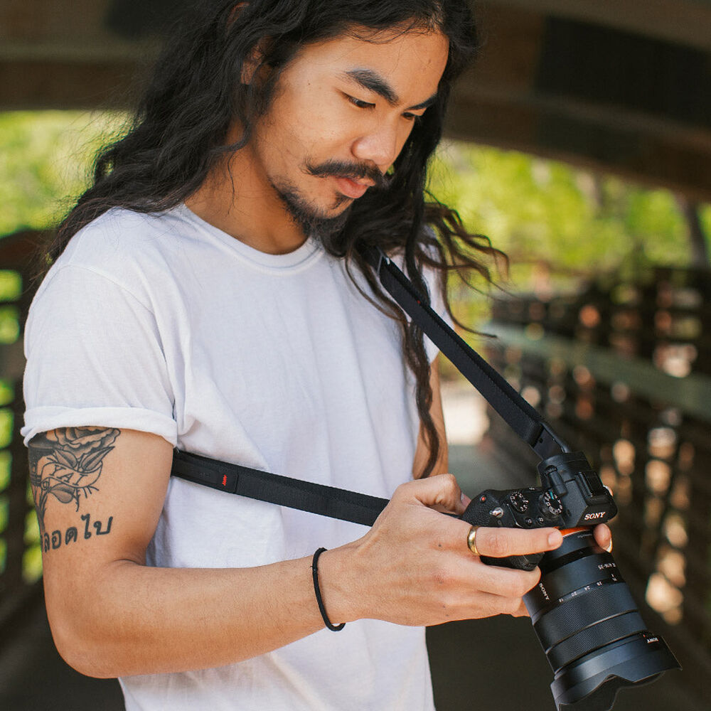 Peak Design Leash ultralight black camera strap, adjustable 83-145 cm, strong nylon webbing, quick-connect anchors rated for 90kg, versatile as sling, neck strap, safety tether, or video stabilizer.
