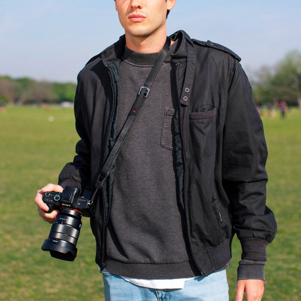 Peak Design Leash ultralight black camera strap, adjustable 83-145 cm, strong nylon webbing, quick-connect anchors rated for 90kg, versatile as sling, neck strap, safety tether, or video stabilizer.