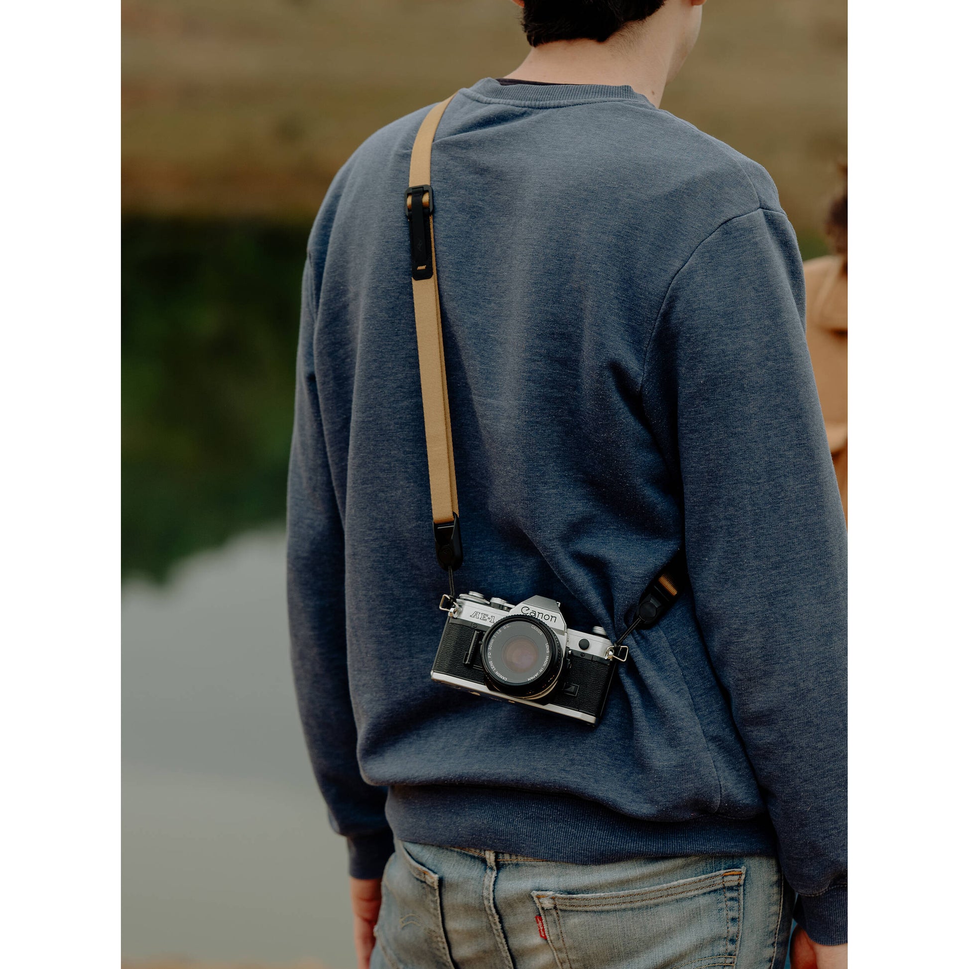 Peak Design Leash camera strap in Coyote color, adjustable length 83-145 cm, ultralight nylon webbing with leather accents, quick-release anchors rated for 90kg, versatile for sling, neck, shoulder, or cross-body use.