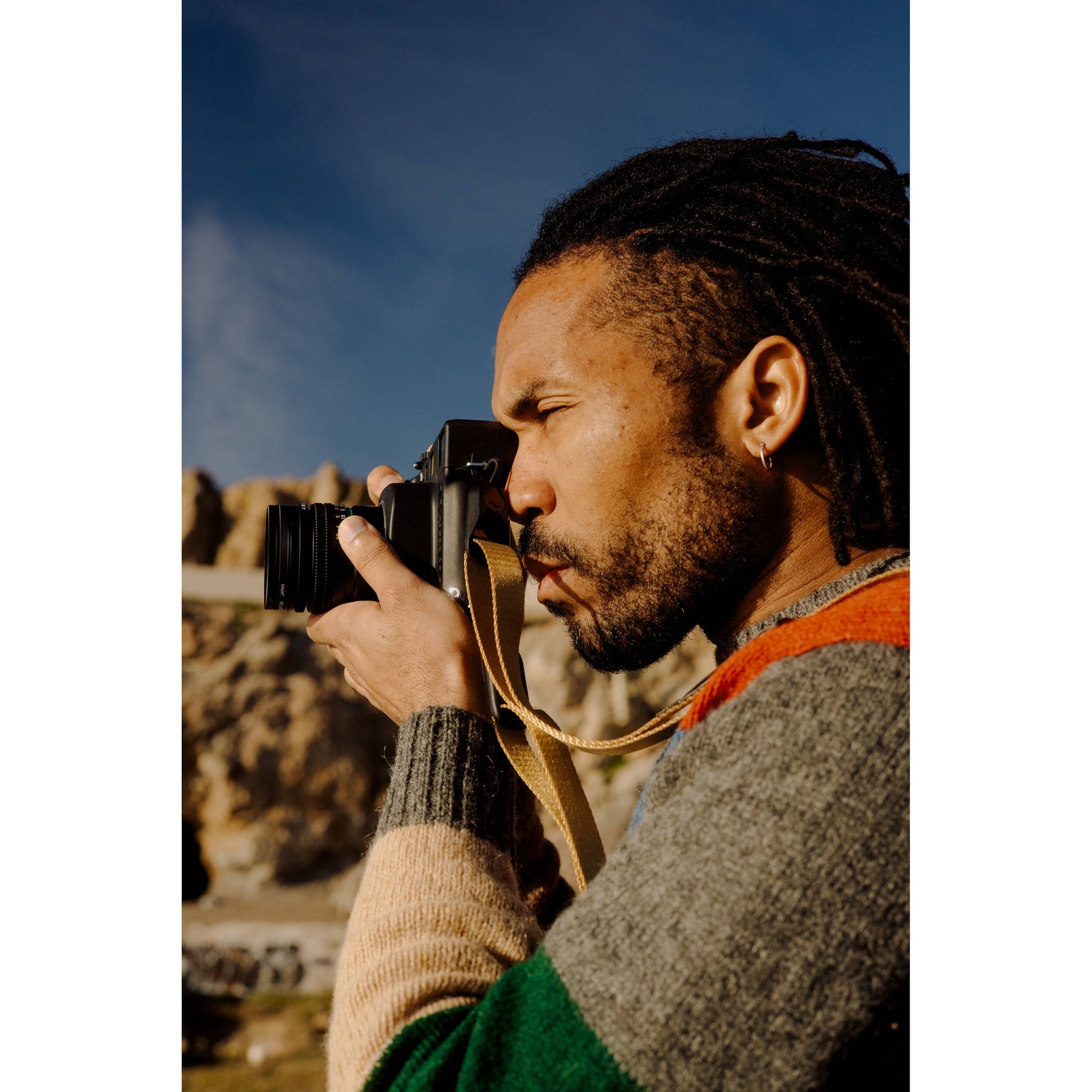 Peak Design Leash camera strap in Coyote color, adjustable length 83-145 cm, ultralight nylon webbing with leather accents, quick-release anchors rated for 90kg, versatile for sling, neck, shoulder, or cross-body use.