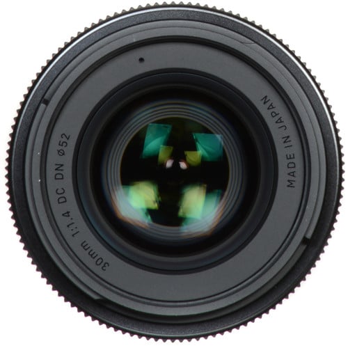 Close-up of a camera lens with 'Made in Japan' text on a white background