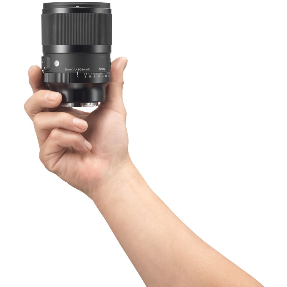Hand holding a camera lens against a white background