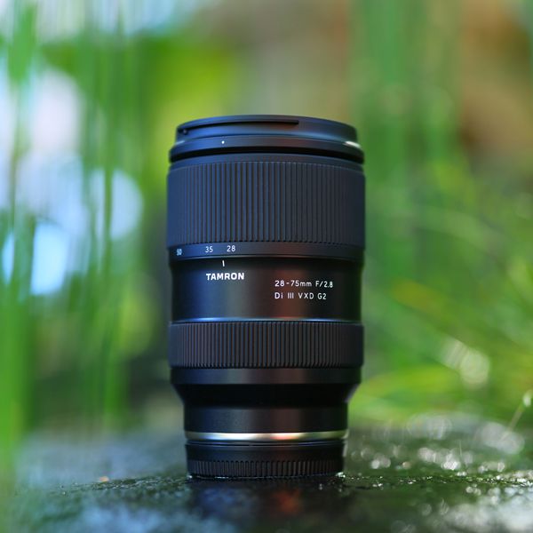 Camera lens on a grassy surface with a blurred natural background