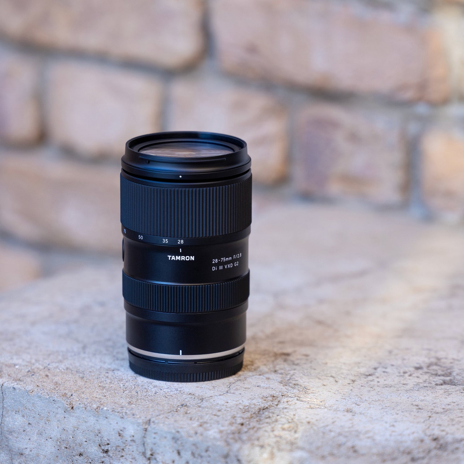 Camera lens on a stone surface with a brick wall background