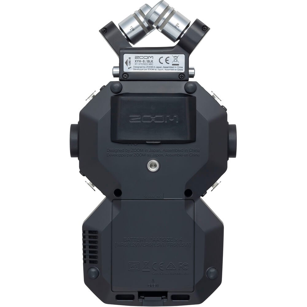 Zoom H8 portable handy recorder showing its color touchscreen, X/Y mic capsule, multiple input gain knobs, outputs and buttons, viewed at slight angle against a neutral background.